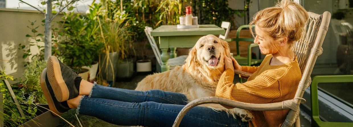 een vrouw geniet met haar hond op het terras