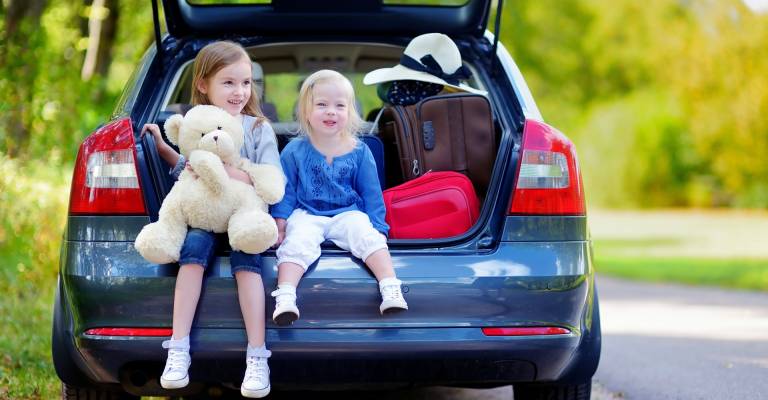 Kinderen achterin de auto op vakantie