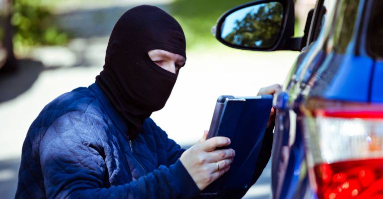 een inbreker bij een auto