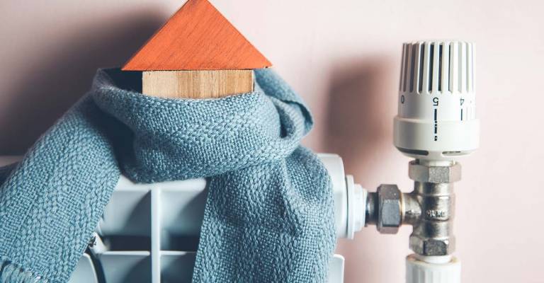 Huismodel met sjaal om op een radiator