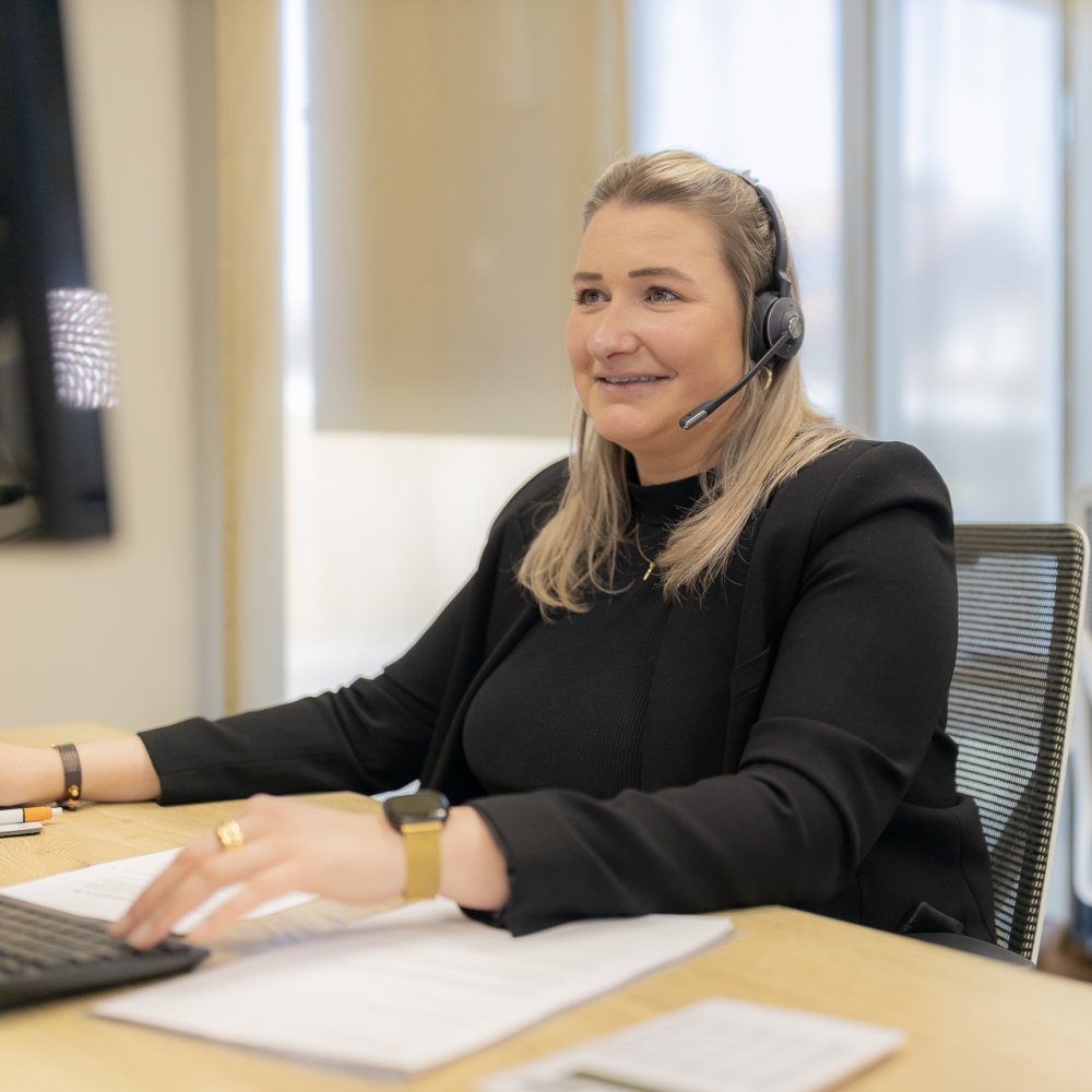 Een medewerker van JacobsVerzekerd met een headset op in gesprek met de klant